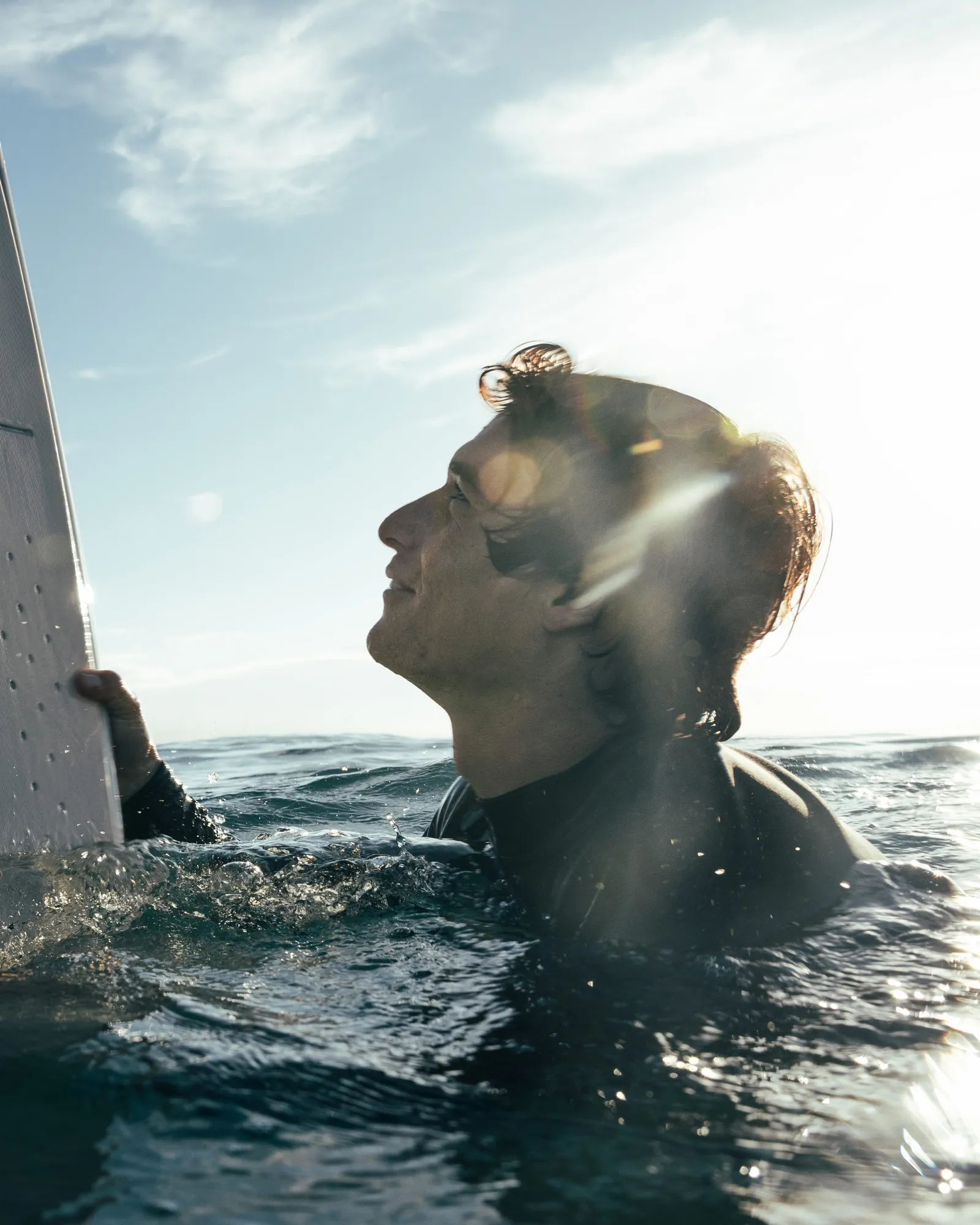 Edo Tanas in the water beside his foil board, Oahu